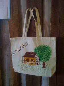This is a photo of a canvas bag with a painted drawing of the Amoureux House.